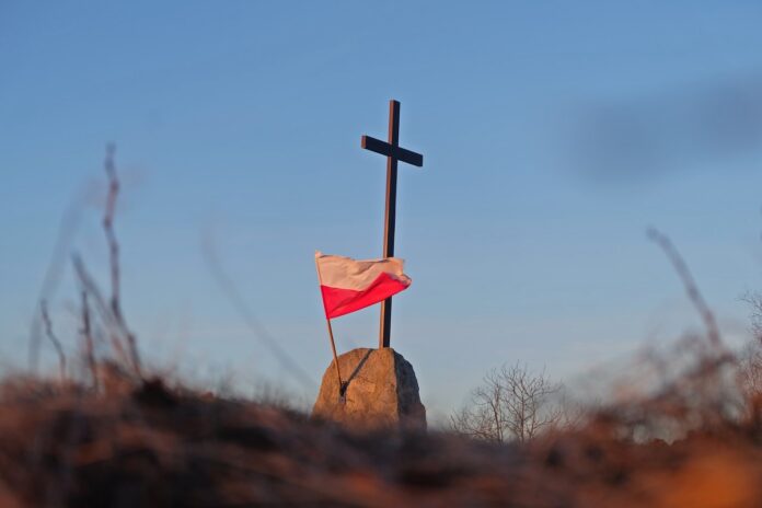 Krzyż i polska flaga.