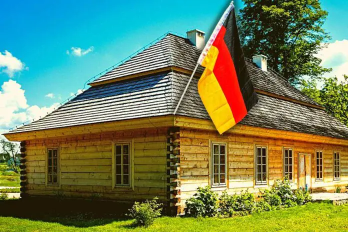 Dom. Drewniany dom. Flaga Niemiec. Niemcy.