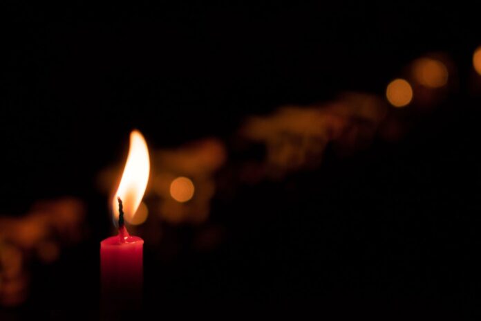 Świeczka, symbolizująca pamięć o zmarłym. Zdjęcie ilustracyjne. / Fot. Andres F. Uran/ Unsplash