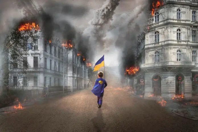 Dziecko z flagą Ukrainy pośród zniszczeń.