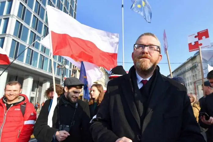 Grzegorz Braun oraz polska flaga na Marszu Niepodległości