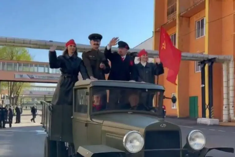 Józef Stalin i Włodzimierz Lenin pod komunistyczną flagą motywują pracowników zakładu metalurgicznego z Homla.