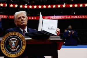 Prezydent USA Donald Trump trzyma rozporządzenie wykonawcze po podpisaniu go podczas inauguracji w hali Capital One Arena w Waszyngtonie, 20 stycznia 2025 r.