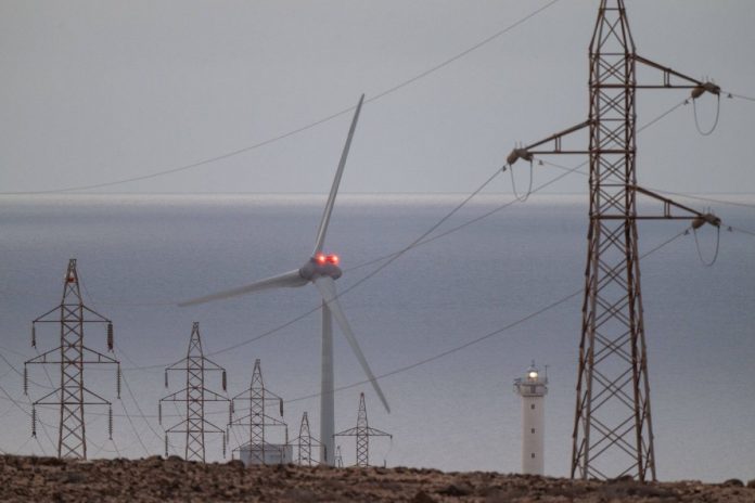 Linia wysokiego napięcia i turbina wiatrowa.