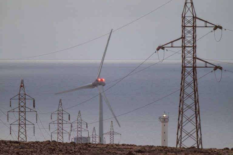 Linia wysokiego napięcia i turbina wiatrowa.