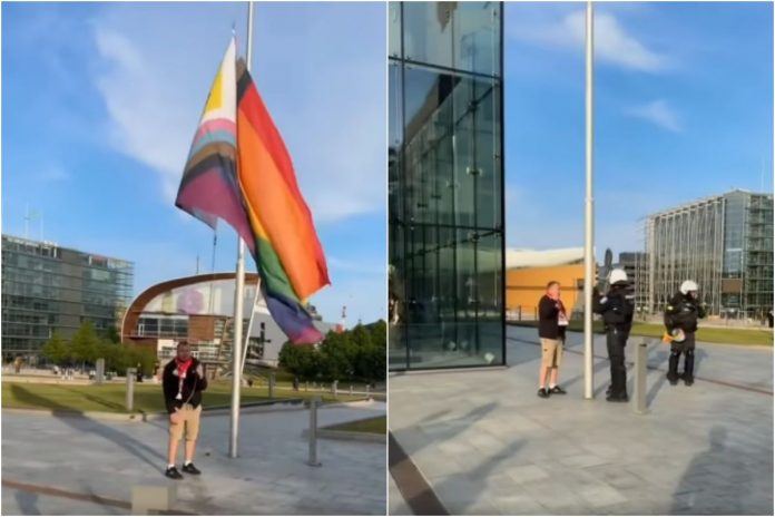 Polski kibic ściąga flagę LGBT w Helsinkach.