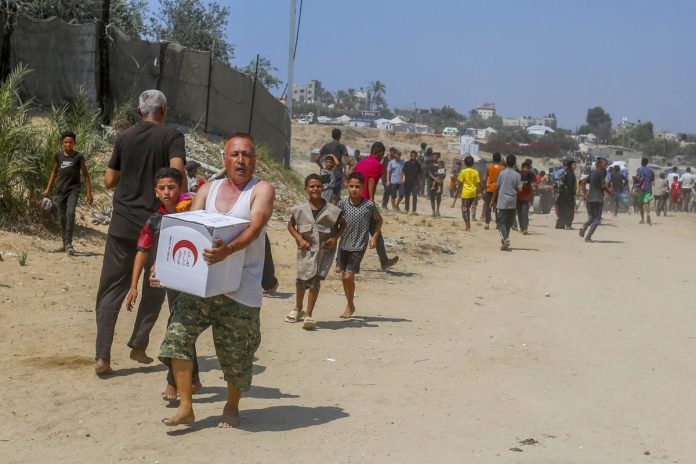 Palestyńczycy w Strefie Gazy w strefie dystrybucji pomocy humanitarnej. Foto: PAP/Abaca