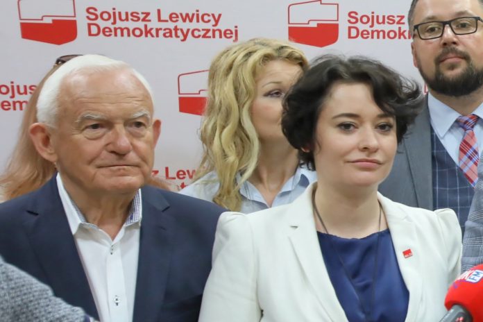 NCZASA.INFO | Zdjęcie z 2019 roku, kiedy Leszek Miller i Anna Maria Żukowska stali ramię w ramię pod czerwonym sztandarem SLD. Dziś ona nazywa go 