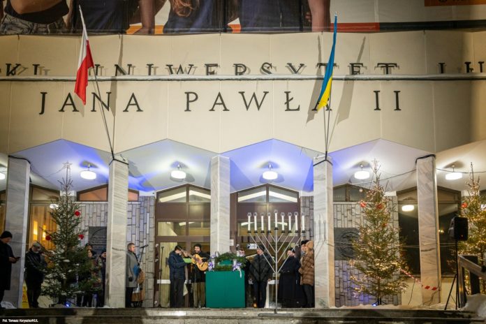 NCZAS.INFO | Jedno zdjęcie, tyle symboli... Świecznik chanukowy i wieniec adwentowy, w otoczeniu bożonarodzeniowych choinek, pod flagami Polski i Ukrainy na Katolickim Uniwersytecie Lubelskim Jana Pawła II. Foto: KUL/Tomasz Koryszko