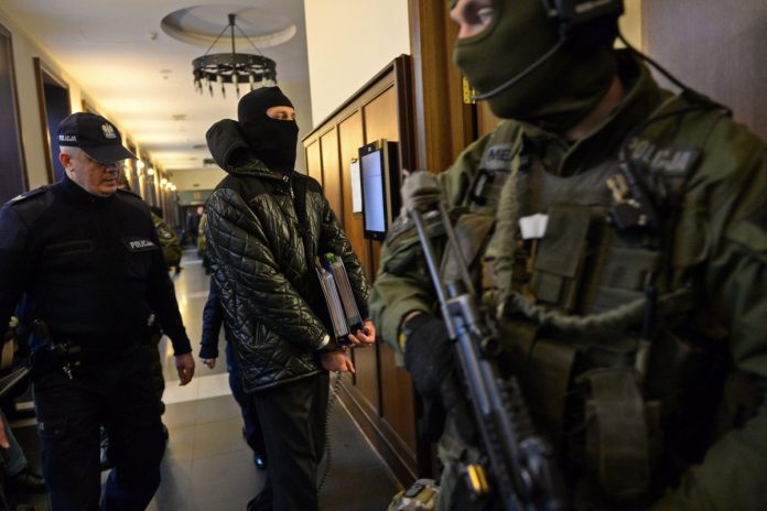 NCZAS.INFO | 17 listopada 2015 r. Igor M. ps. Patyk, w towarzystwie policyjnej obstawy, wkracza na salę rozpraw. / Foto: PAP