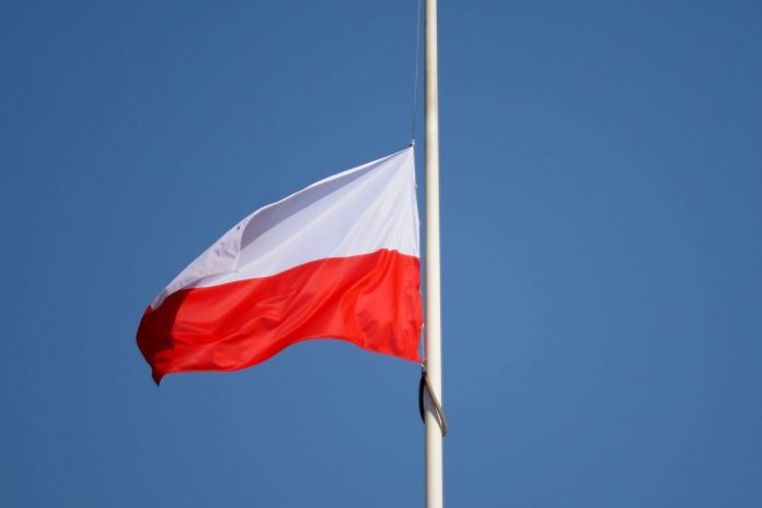 Opuszczona do połowy masztu flaga Polski.