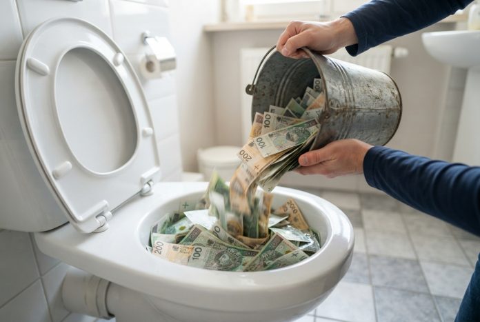 Spuszczanie pieniędzy w toalecie.