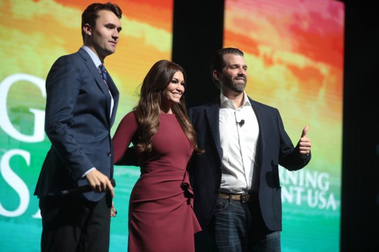 NCZAS.INFO | Zdjęcie ilustracyjne. Kimberly Guilfoyle z Charliem Kirkiem (po lewej) i Donaldem Trumpem Jr. (po prawej) w Palm Beach County Convention Center w 2019 r.